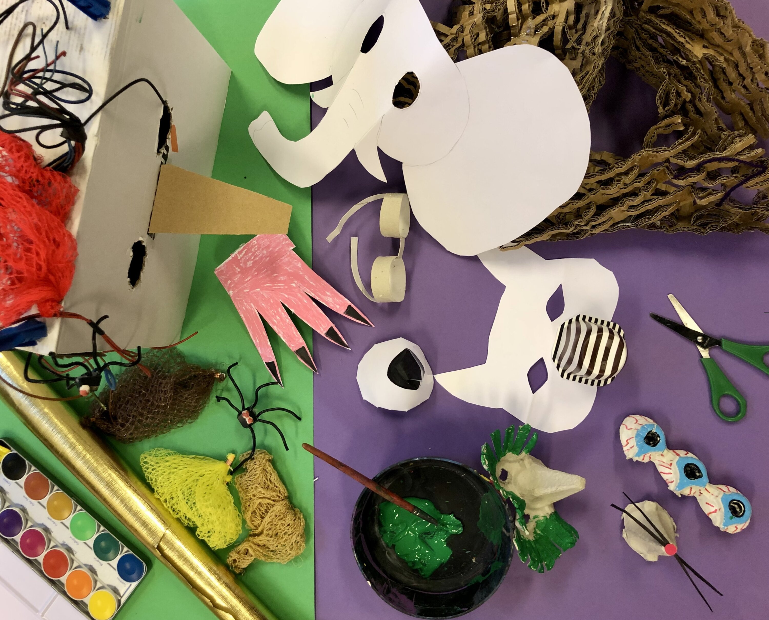 Workshopmaterialien wie Papier, Tiermasken, Schere und Farben