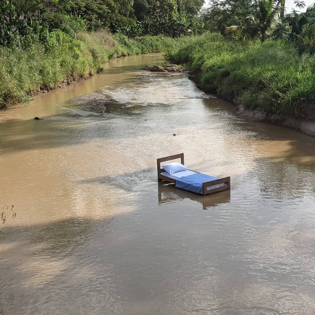 A bed stands in a river.