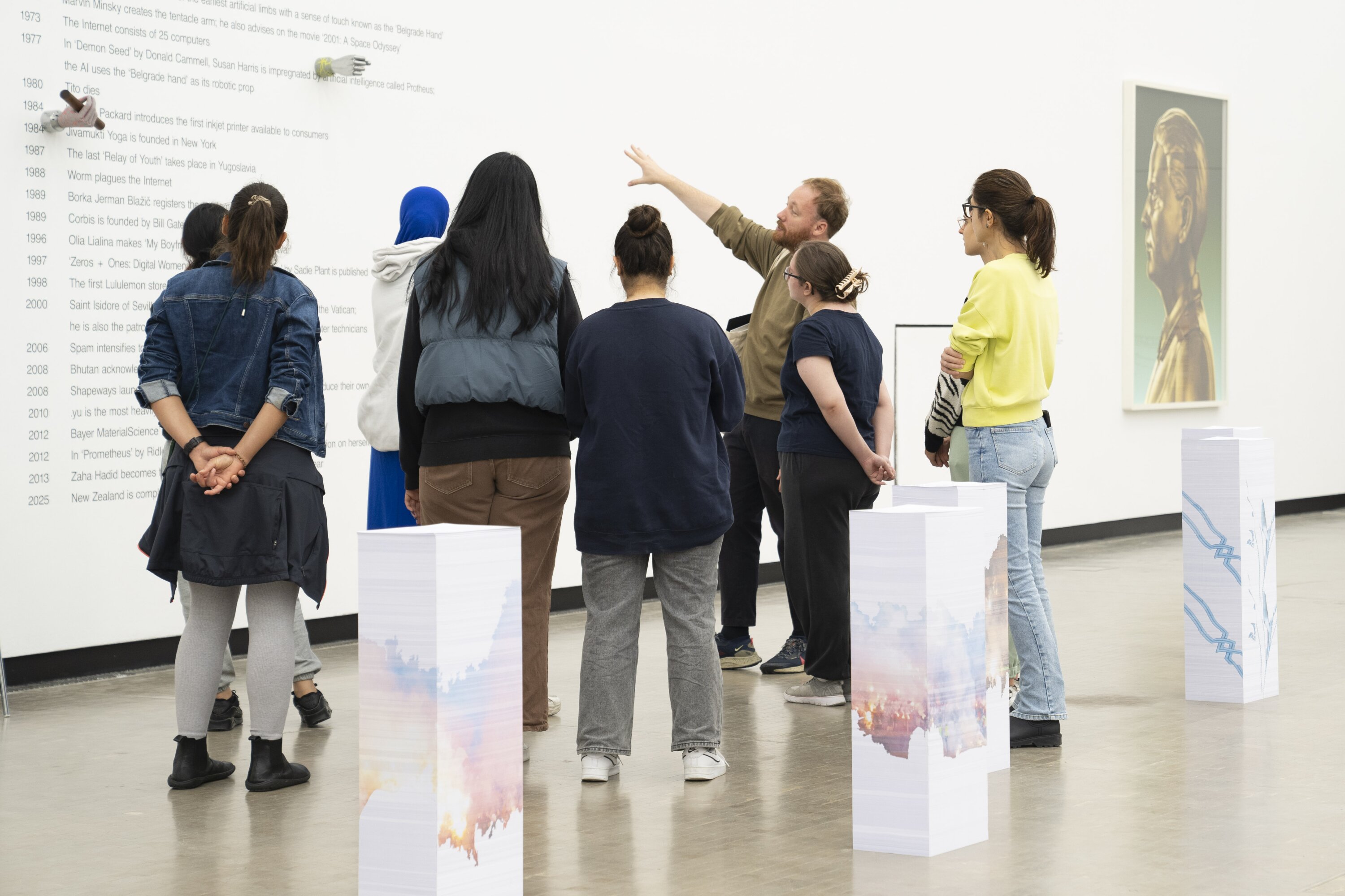 Eine Gruppe betrachtet Kunstwerke von Aleksandra Domanović.