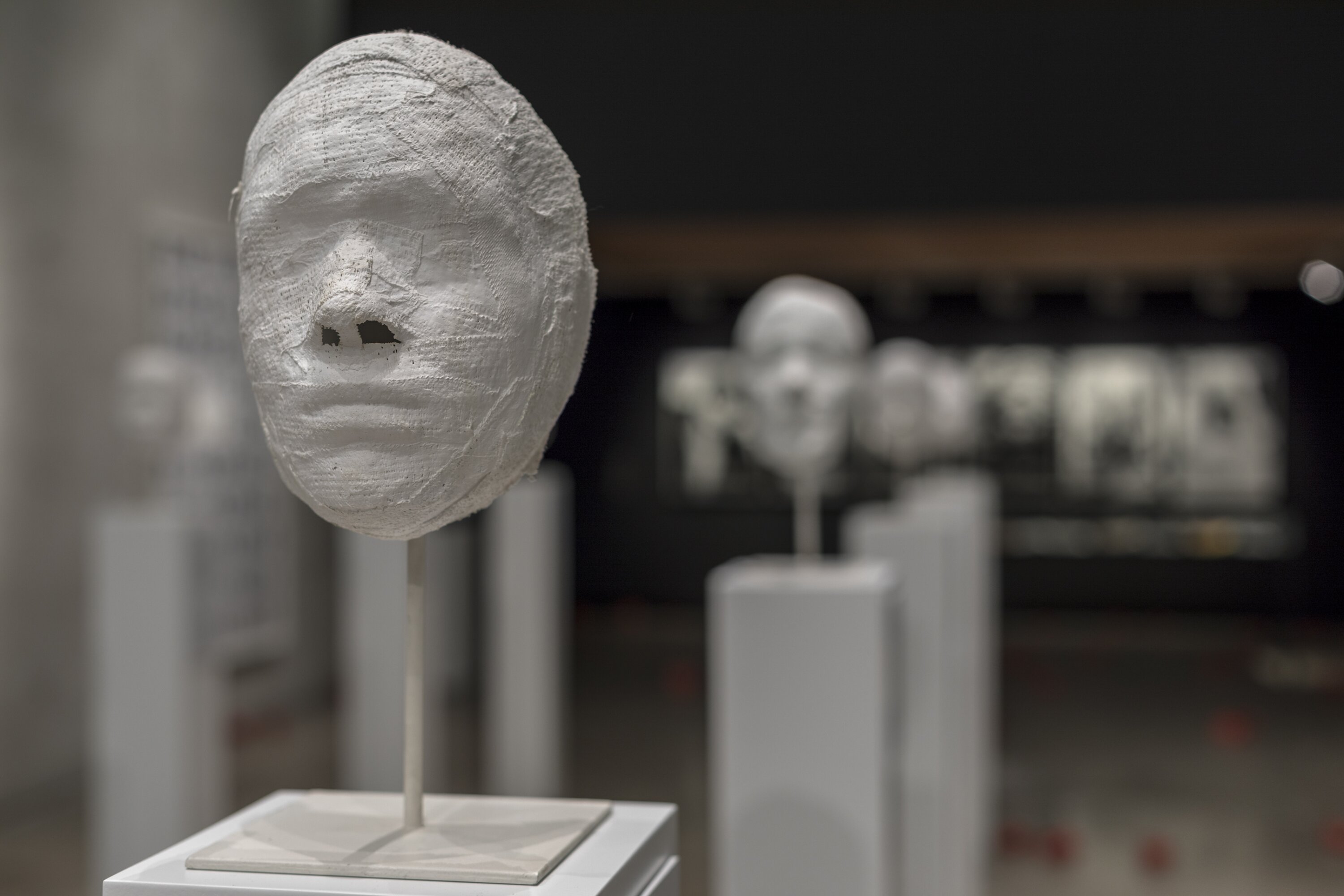 Die Ausstellungsansicht zeigt Gesichtsabdrücke von Frauen auf Sockeln.