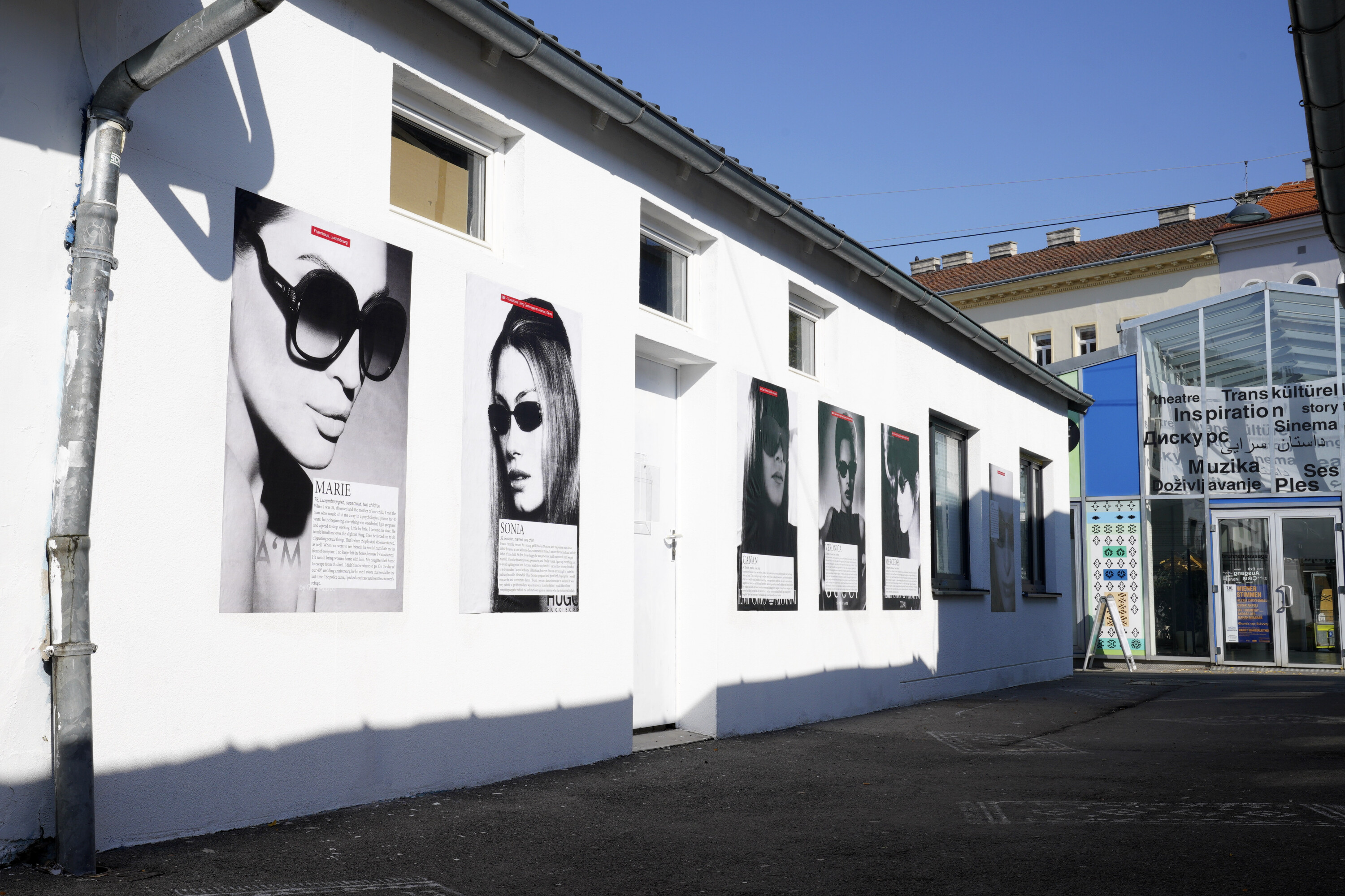 An einer Hausfassade hängen mehrere große Plakate von Sanja Iveković.