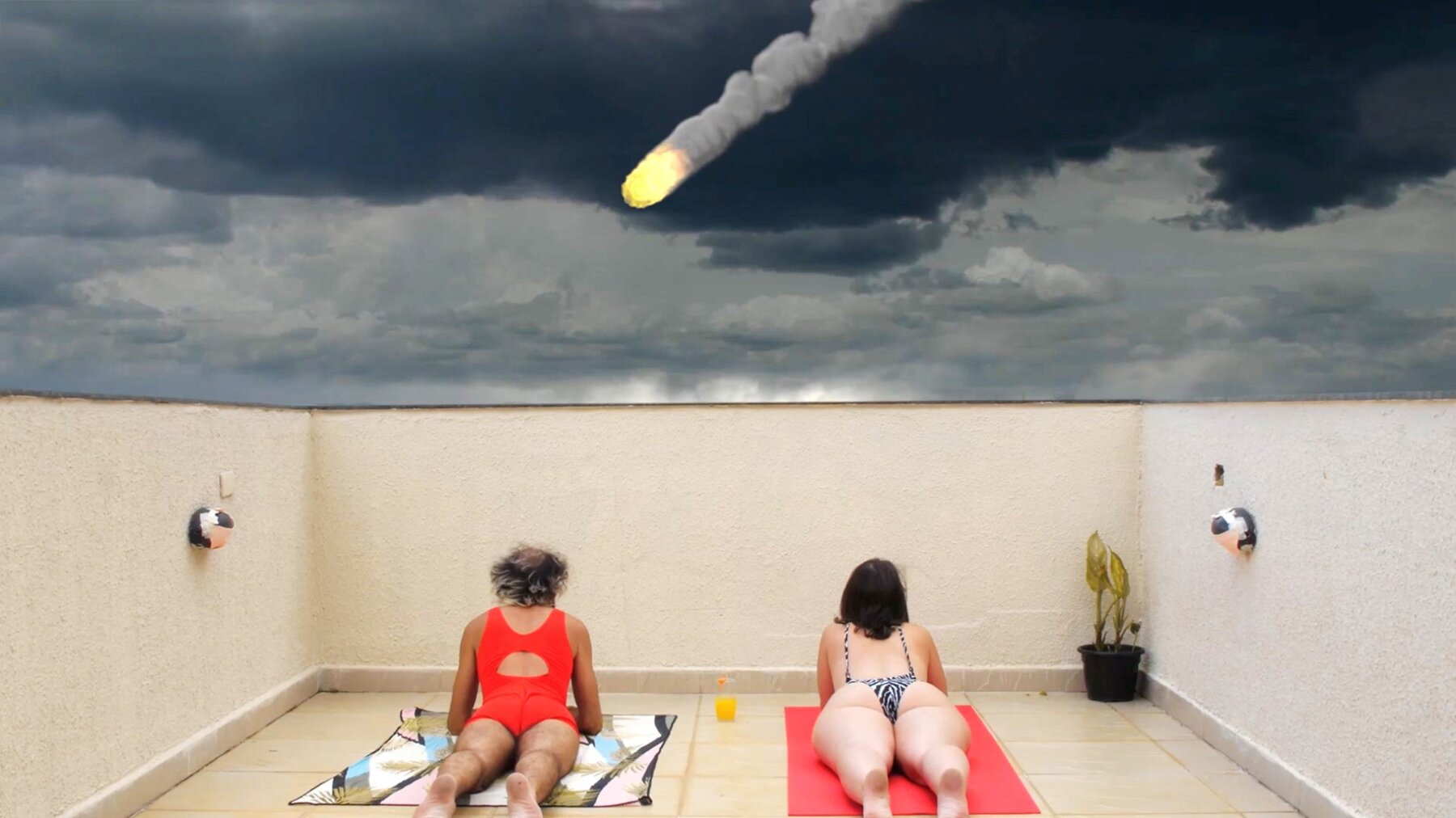 Zwei Personen liegen auf Strandt&uuml;chern und schauen auf eine Leinwand.