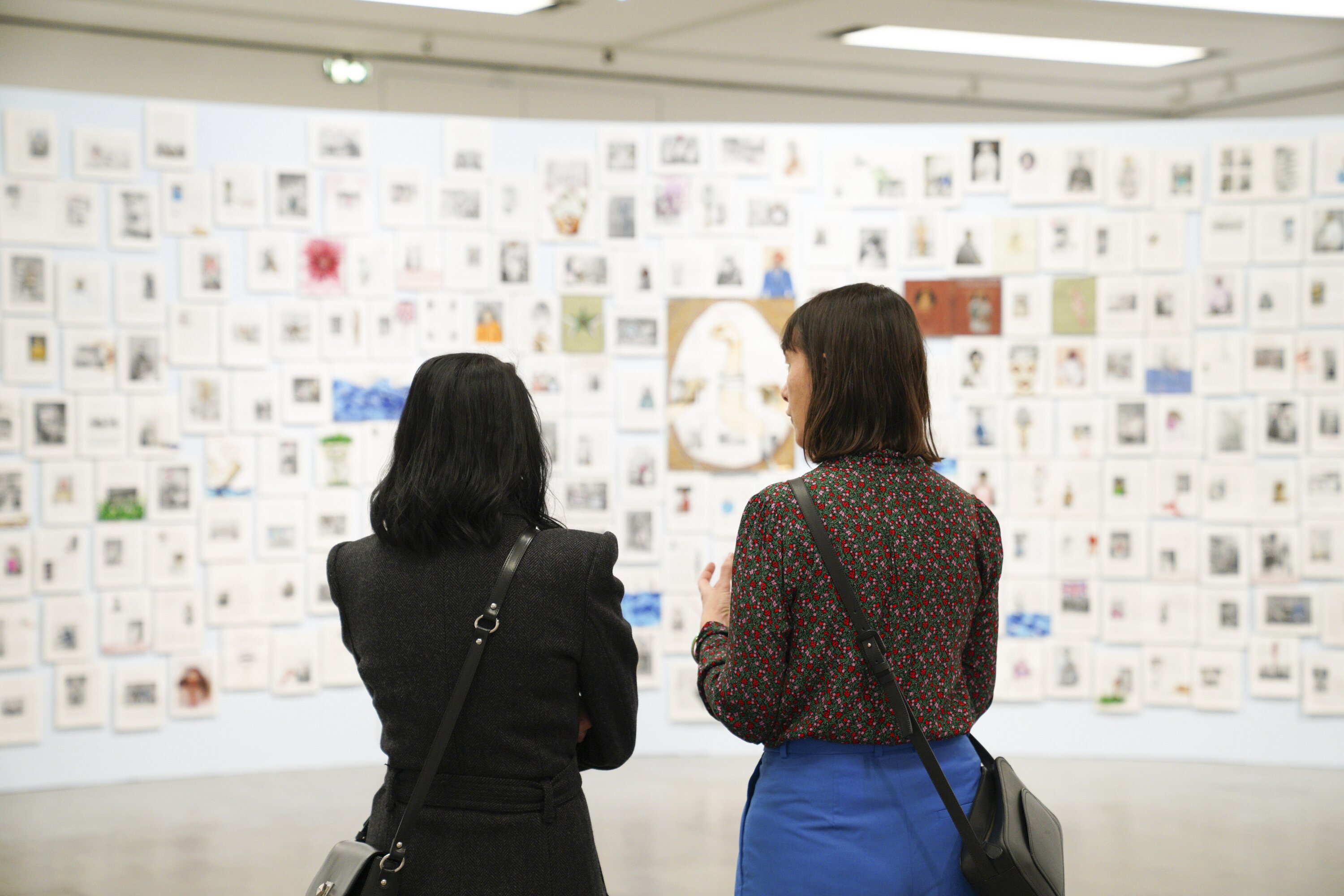 Zwei Personen betrachten ein Kunstwerk von Rajkamal Kahlon.