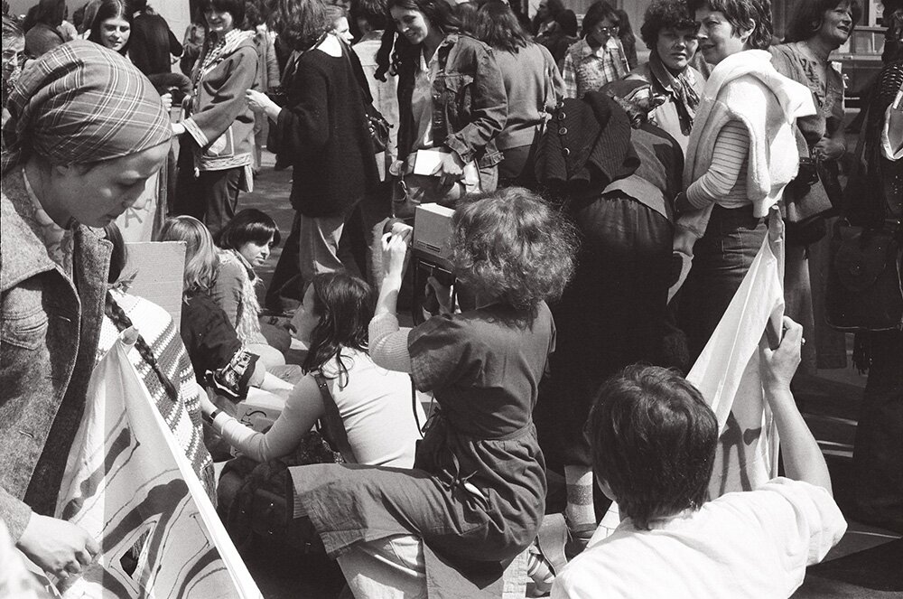 Delphine Seyrig filmt Où est-ce qu’on se “mai”? [Wohin sollen wir uns wenden (um für unsere Rechte zu kämpfen)?] während der Demonstration zum 1. Mai 1976