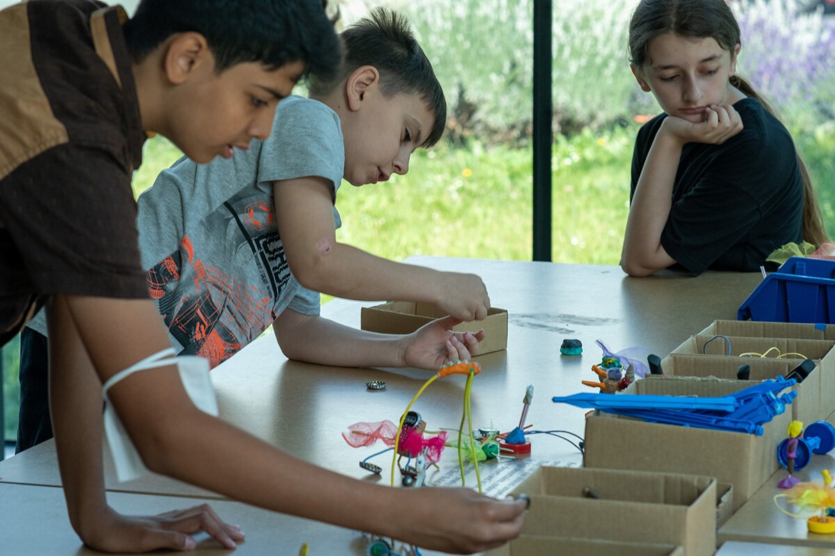 Drei Kinder basteln in der Ausstellung