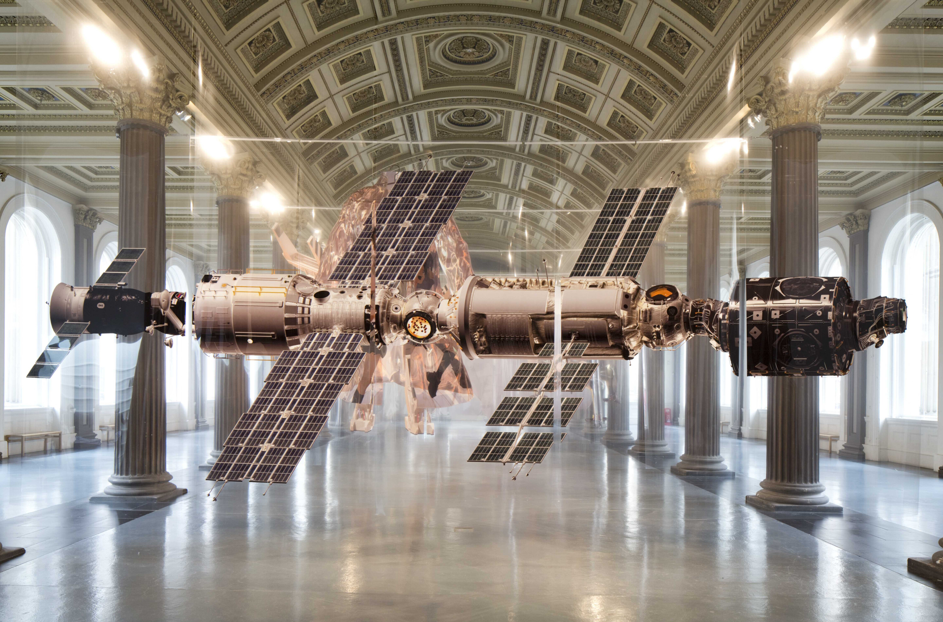 Zwei Satelliten hängen in einem Ausstellungsraum.