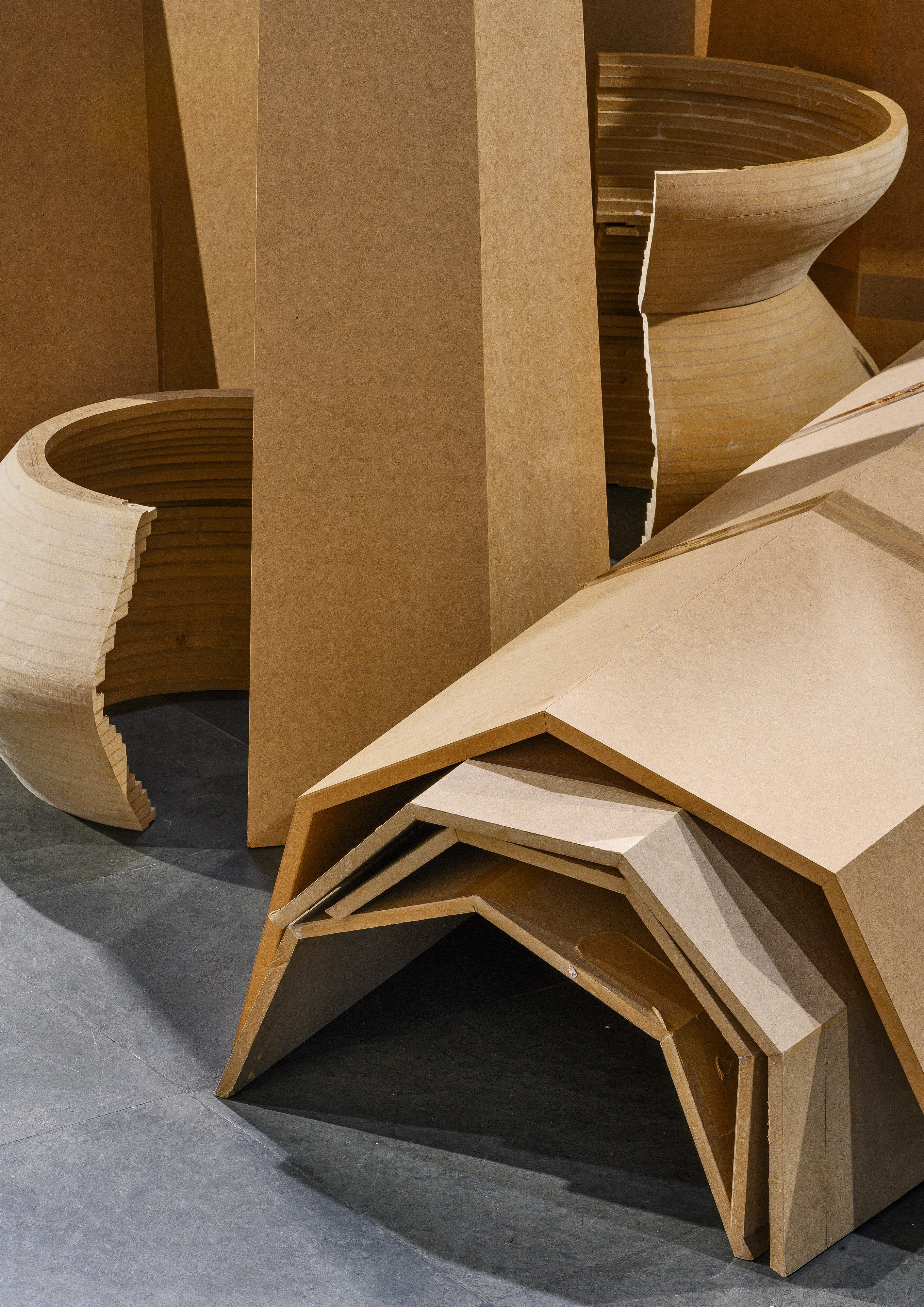 Ausstellungsansicht mit mehreren hölzernen Skulpturteilen, die liegen und stehen.